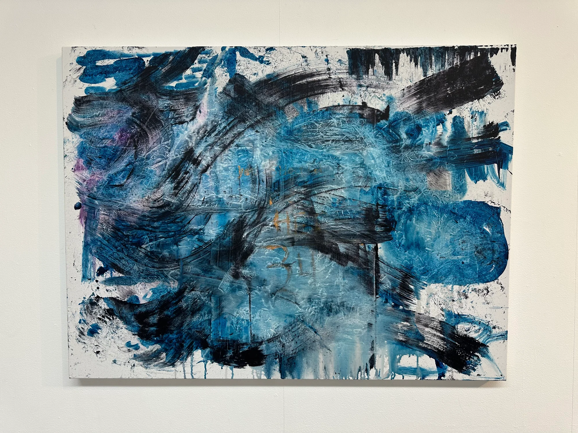 An abstract painting comprised of black and blue strokes with minimally visible text reading “you should be here, 34”