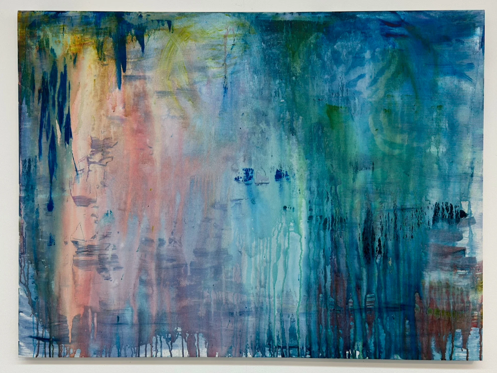 An abstract blue wash painting with pops of yellow, red and green throughout.