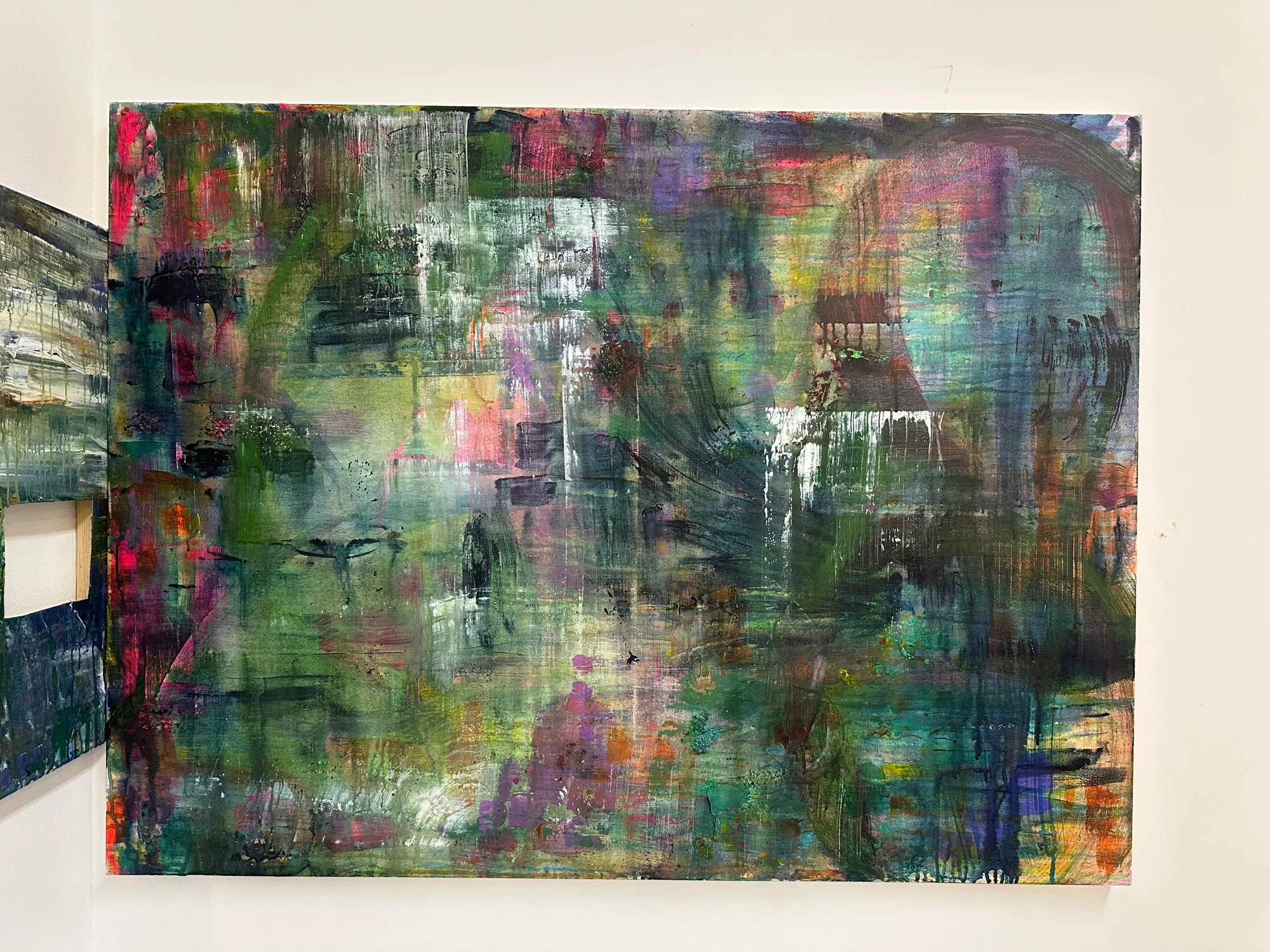Abstract painting with many different colors, green as the main one.