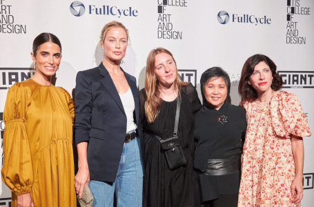 Five women pose in front of an photo-op backdrop at the Los Angeles Fashion Week