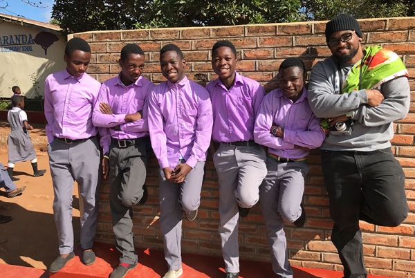 Students pose on a wall outside the Jacaranda School.