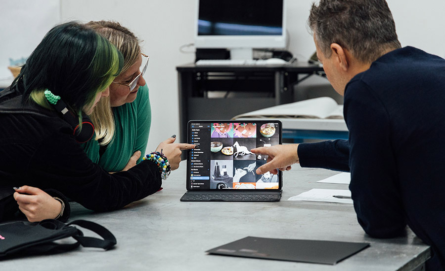 People reviewing artwork on a computer
