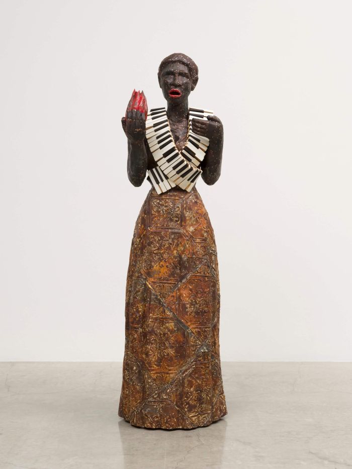 Alison Saar, Torch Song, 2020 (Wood, ceiling tin, copper, found belt and piano keys, 72 by 24 by 24 inches)