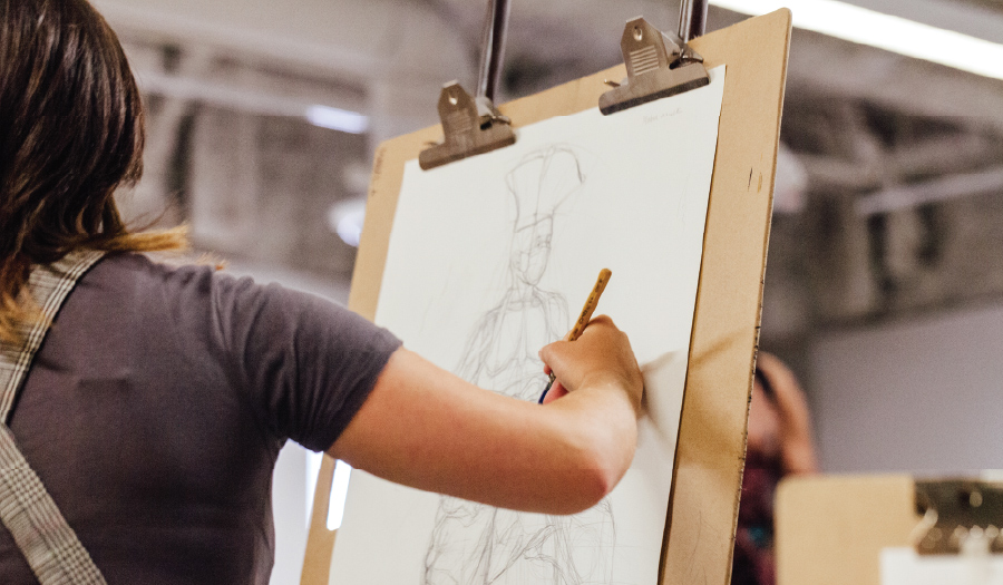 Otis Extension student drawing at an easel