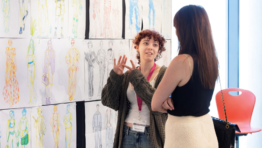 Summer of Art fashion students looking at sketches