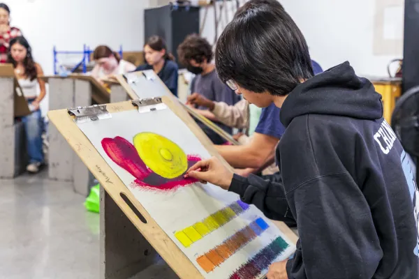 A Summer of Art class with the student in the foreground working on a painting of a snail.