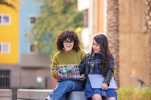 Two students on the Otis College campus discuss their portfolios