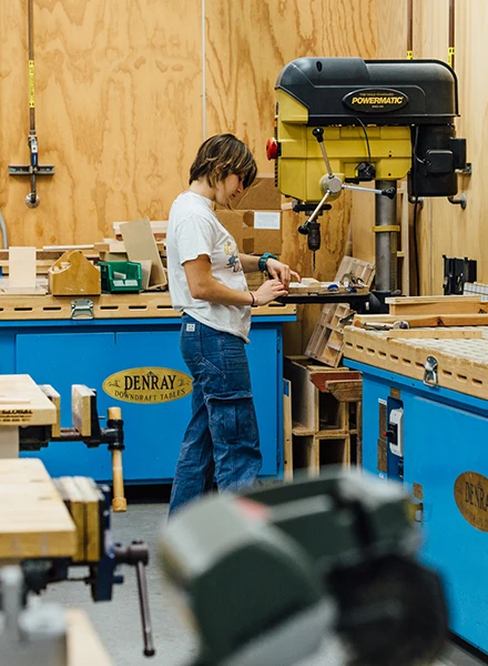 Image of student using machine in a wood shop