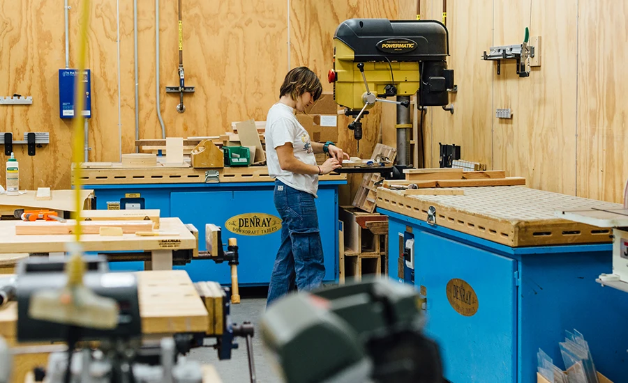 Image of student using machine in a wood shop