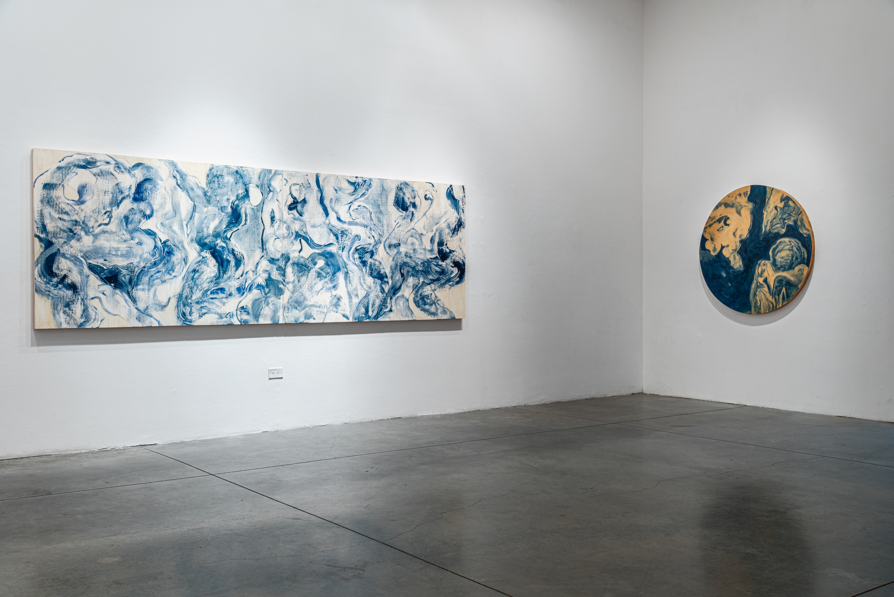 Installation view of 2 paintings done in the key of blue in a gallery
