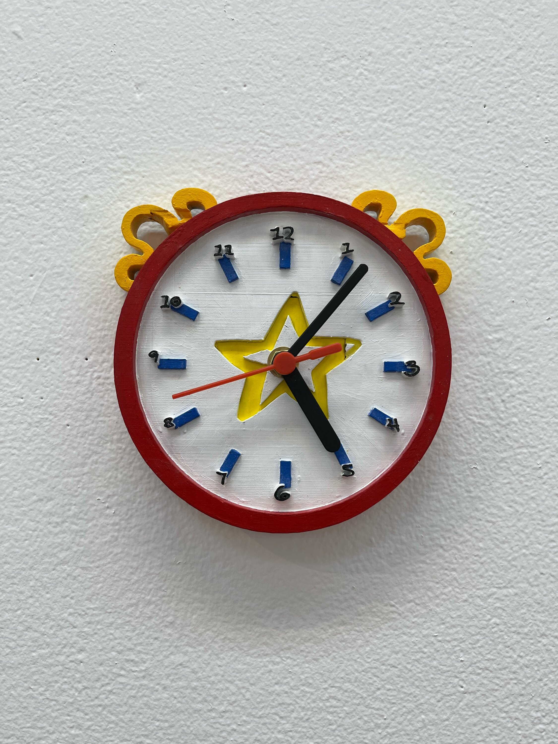 A red, blue and yellow clock with a star in the middle