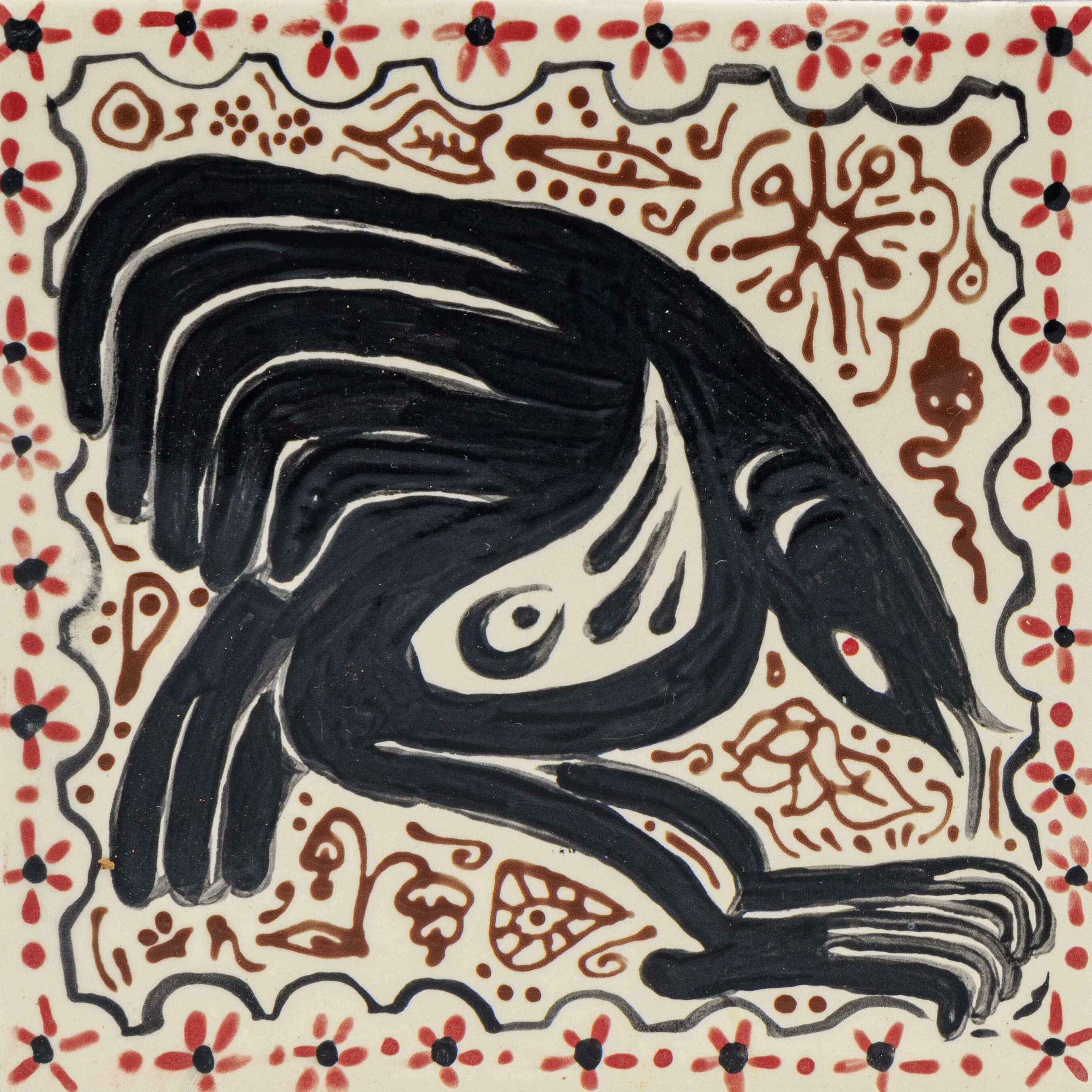White ceramic tile with a black bird and red and brown background designs. 
