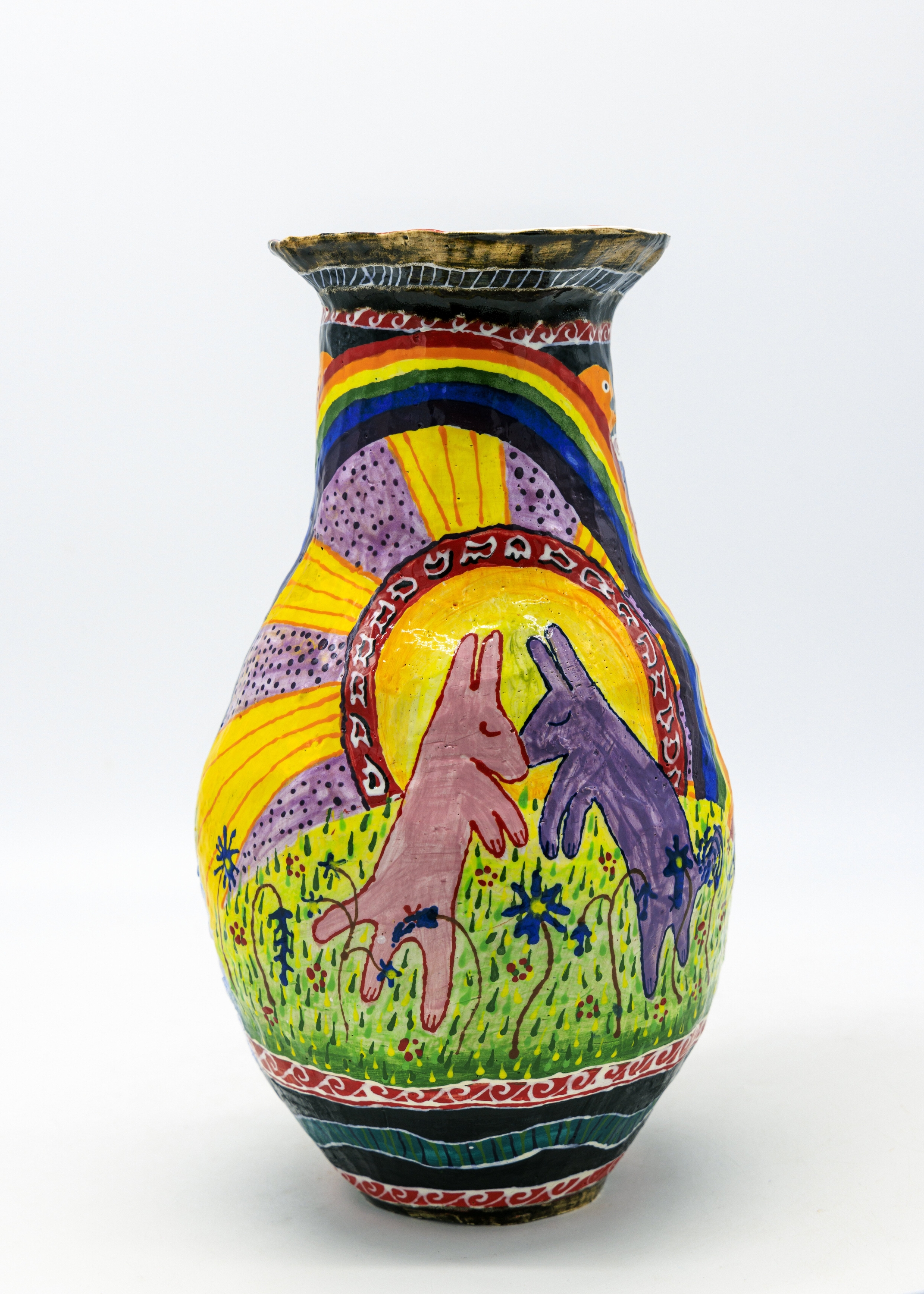 Ceramic vase with a painted scene of two animals resting on each other, with a rainbow and plants in the background.