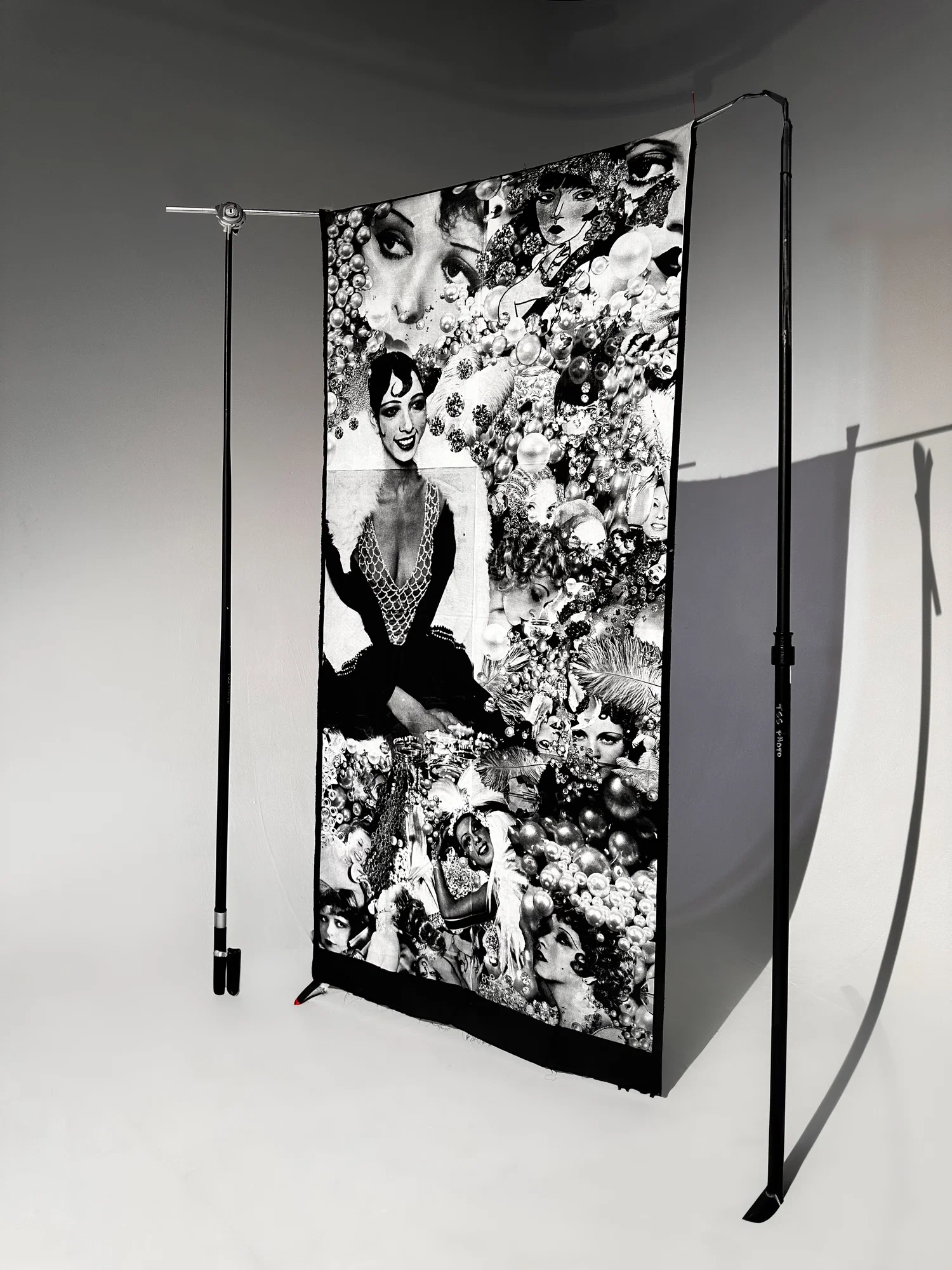 A black and white, silkscreen-printed tapestry containing an elaborate collage of various images of Josephine Baker and flappers from the 1920s