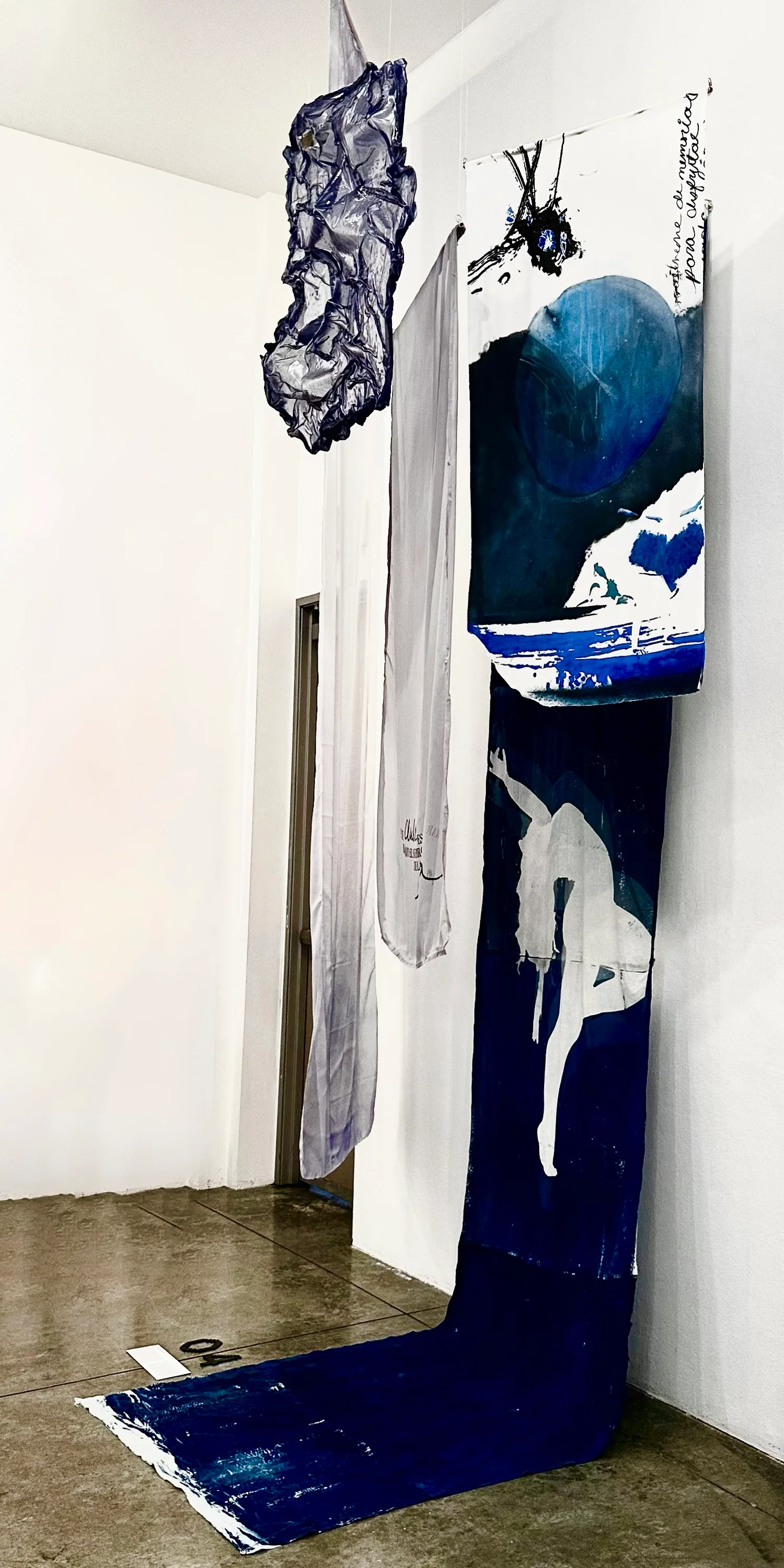 A large installation consisting of several fabric panels at alternating heights in various shades of blue.