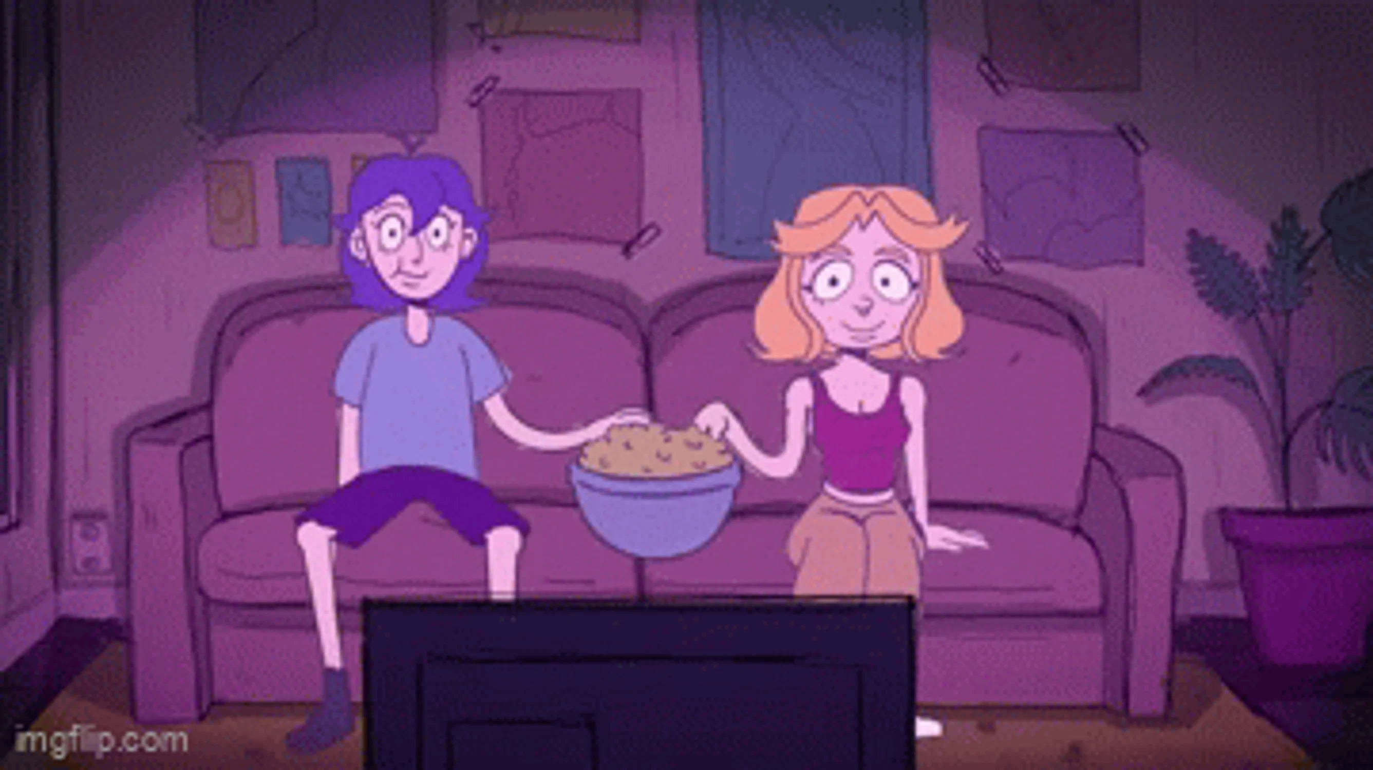 Two girls are on a couch watching TV and sharing a bowl of popcorn.
