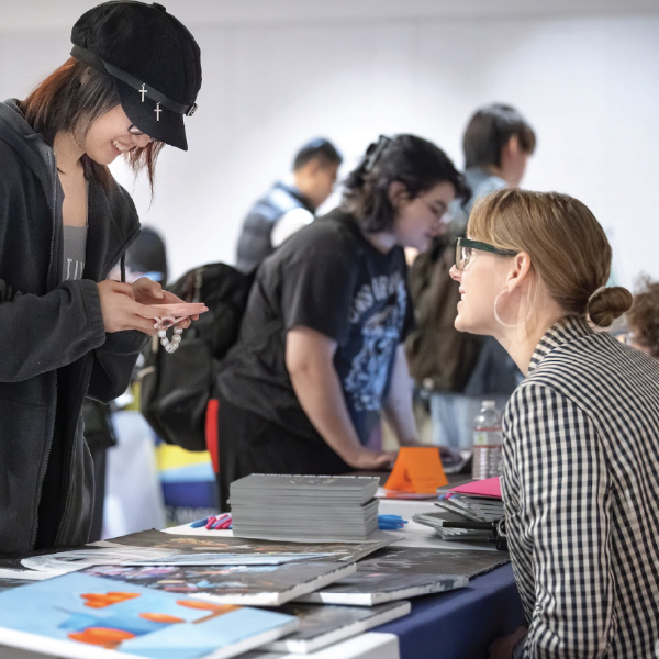 Student showing their portfolio to a professor