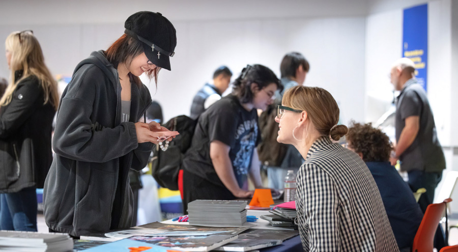 Admissions counselor speaking with student at national portfolio day