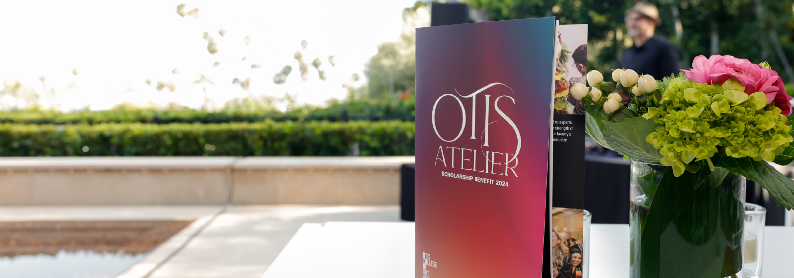 Otis Atelier event program sitting on white table outside