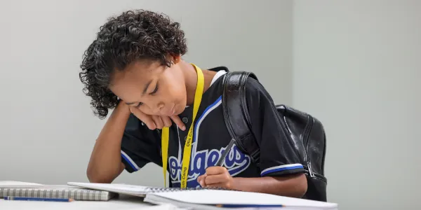 Male Summer Youth Camp student works on his graphic novel