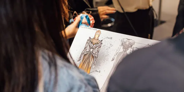 Student checking a fashion illustration