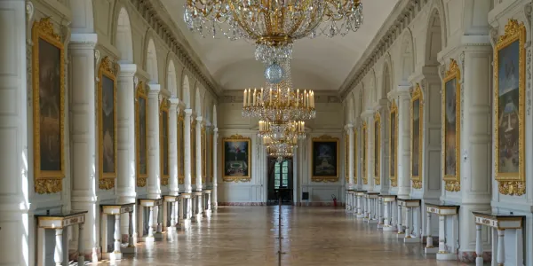 Versailles hallway with chandeliers and side tables