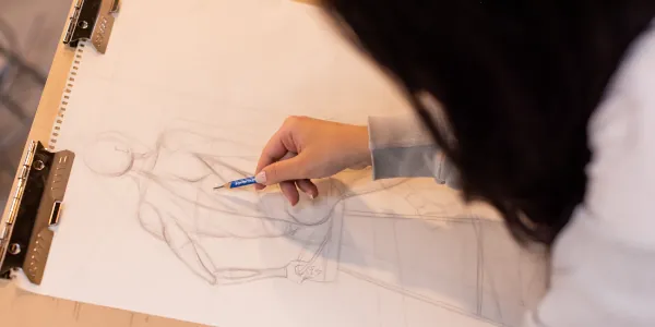 Student drawing a life drawing model