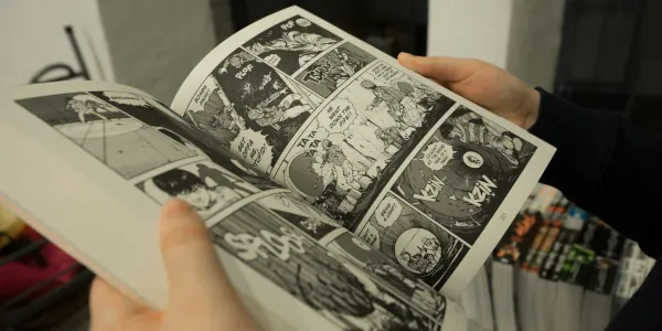 Person with just his hands visible reading a graphic novel