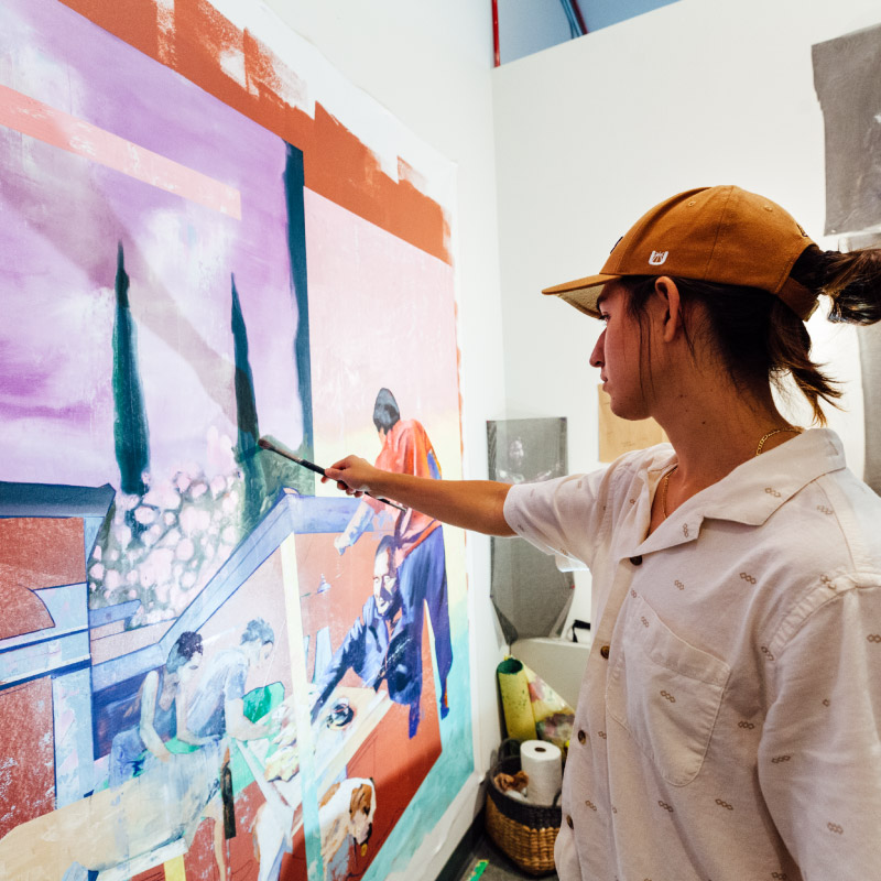 Graduate fine arts student painting in his studio