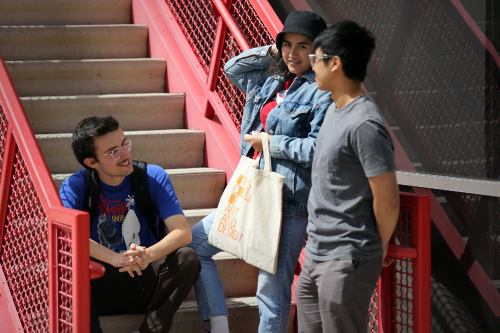 Three students talking on stairway