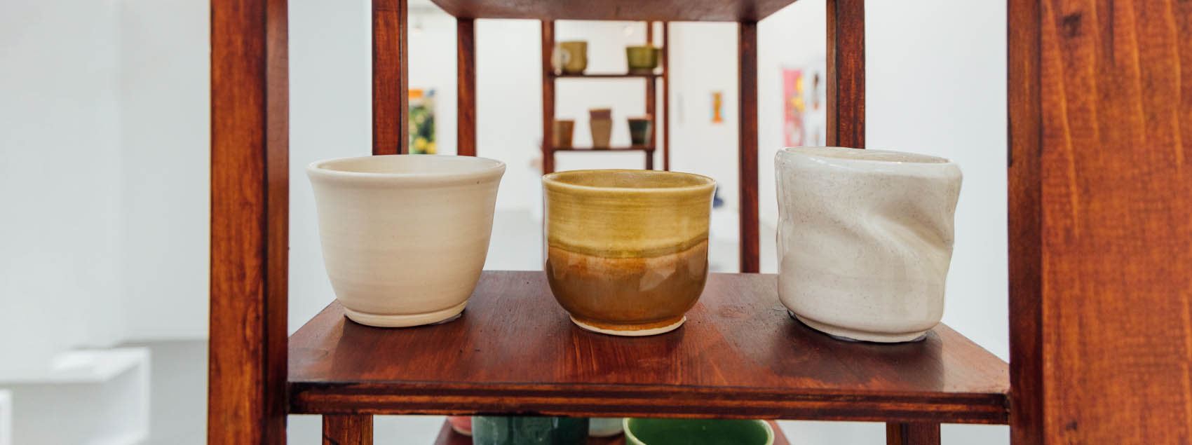 Ceramics sitting in a row on a shelf