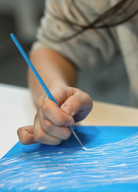 Student painting blue artwork