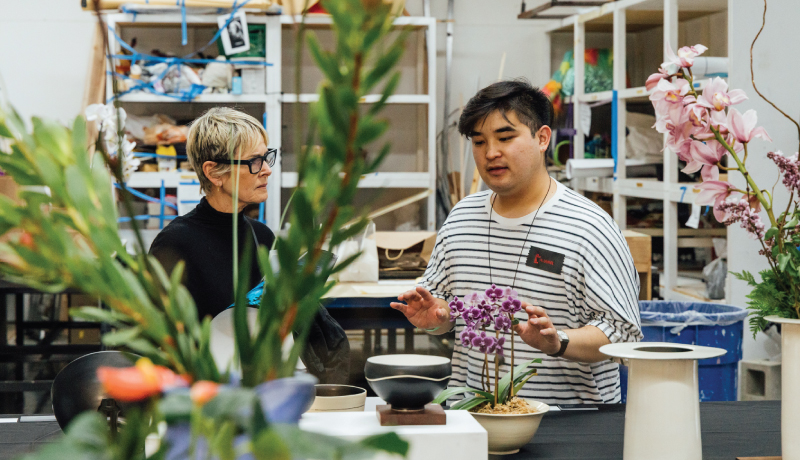 Ceramics studio instructor speaking with student