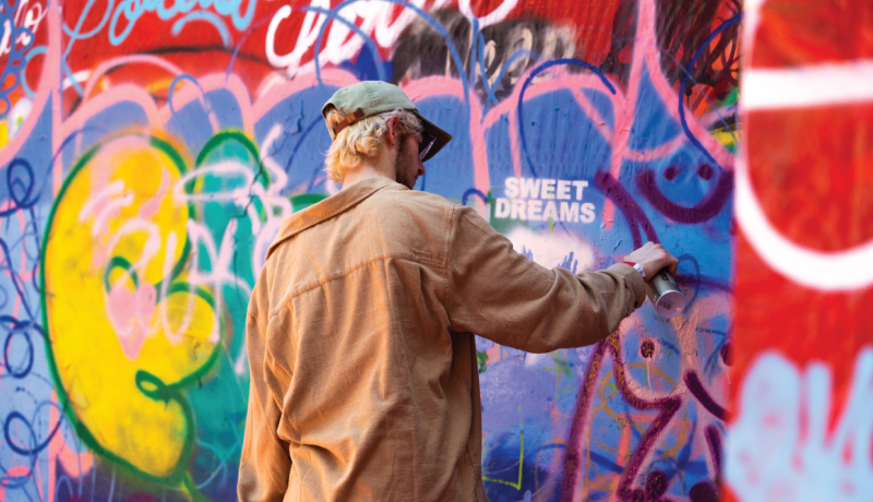 Student painting mural on the wall