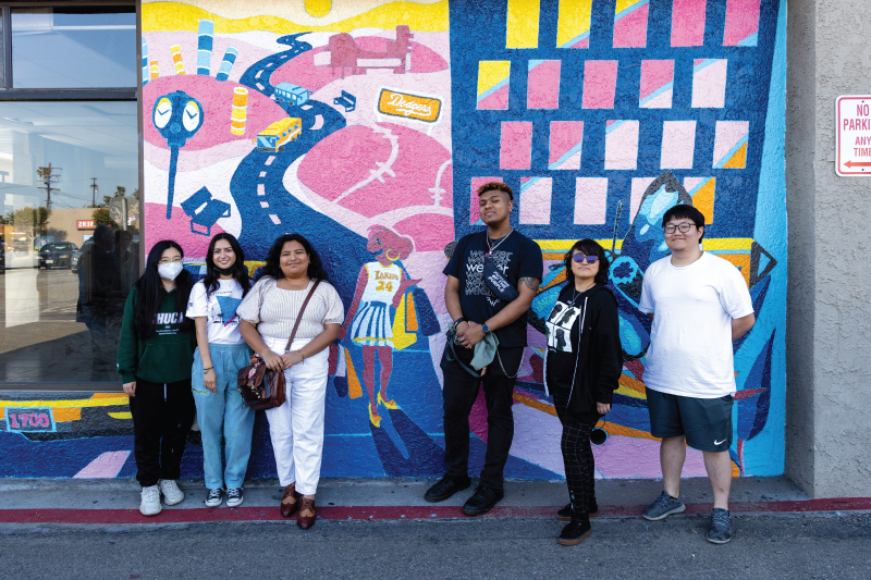 Creative Action students standing outside of outdoor mural