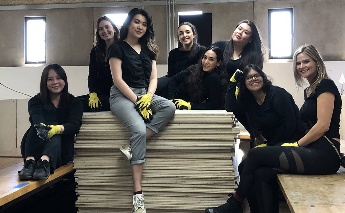Proud and exhausted seniors posing on 109 sheets of plywood