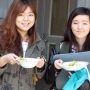 Students holding their bowls of soup at the Banquet