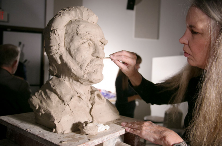 Artist sculpting bust of veteran alumnus